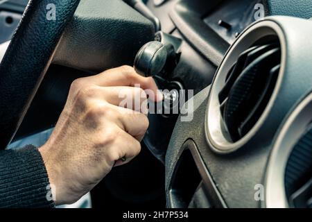 Eine Hand, die den Schlüssel zum Starten des Fahrzeugs hält. Stockfoto