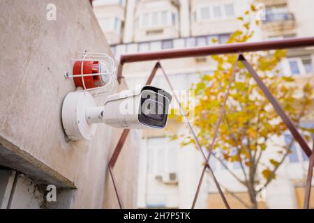 Details mit einer CCTV-Kamera an einer Wand außerhalb eines Gebäudes. Stockfoto