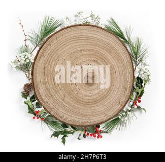 Rundes Holzschild mit Weihnachtskranz aus Kiefernästen mit Ilex-Blättern Stockfoto