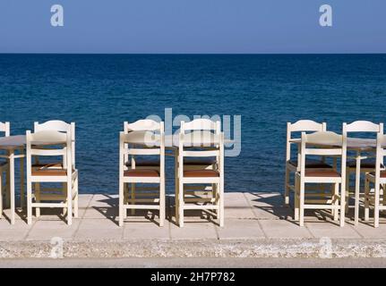 Leere Tische und Stühle vor dem Meer, Limnos, Griechenland Stockfoto