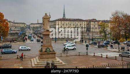 Statue eines Königs Vittorio Emanuele I, der vorwärts geht, einen Stab in seinem rechten Arm hält und der Ponte Vittorio Emanuele I über dem Fluss Po, Turin, gegenübersteht Stockfoto