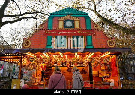 Traditioneller Weihnachtsstand auf dem Weihnachtsmarkt 2021 in der Königsallee in Düsseldorf, der geröstete Mandeln und Lebkuchenherzen verkauft. Stockfoto