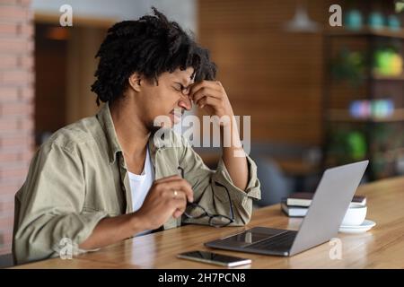 Eye Strain Konzept. Black Guy Müde Nach Der Arbeit An Laptop Im Café Stockfoto