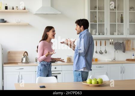 Wütend unglückliche junge europäische Frau und Mann kämpfen, schreiend und gestikulend Stockfoto