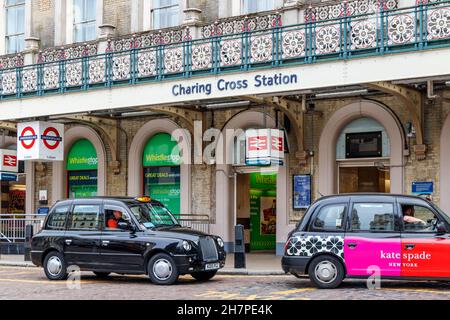 Schwarze Londoner Taxis befinden sich auf dem Vorplatz der Charing Cross Station on the Strand, London, Großbritannien Stockfoto