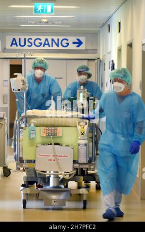 Leipzig, Deutschland. 08th. November 2021. In der Covid-Station, einem Bereich der operativen Intensivstation des Universitätsklinikums Leipzig, Rollen Ärzte, Krankenschwestern und Pfleger einen Patienten in den Raum. Auf der Intensivstation wächst seit Tagen die Zahl der Corona-Patienten mit schweren Verläufen, darunter immer mehr jüngere Patienten im Alter zwischen 30 und 60 Jahren. Quelle: Waltraud Grubitzsch/dpa-Zentralbild/ZB/dpa/Alamy Live News Stockfoto