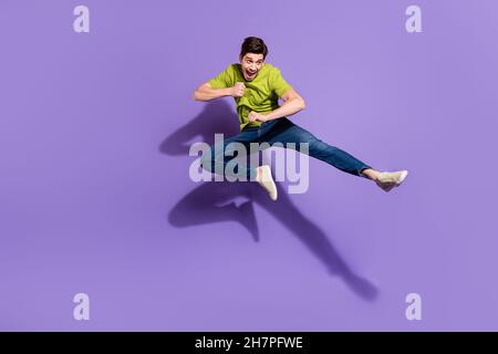 In voller Länge Körpergröße Ansicht der schönen fröhlichen Kerl springen Kampf isoliert über lebendige violett lila Farbe Hintergrund Stockfoto
