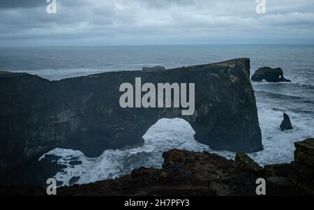 Einzigartiger Basaltbogen am Dyrholaey Cape. Naturschutzgebiet, Island. Landschaftsfotografie. Kap Dyrholaey ist der südlichste Punkt Islands. Stockfoto
