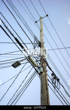 Kabel, Glasfaserkabel und Stromleitungen am Mast. Mast mit Stromkabeln und Kommunikationsleitungen Stockfoto