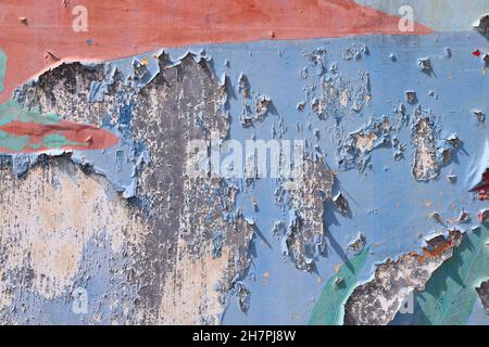 Abblätternde Farbstruktur. Bunte Farbe schält sich von der Metalloberfläche. Stockfoto