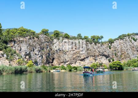 Ausflugsboote auf dem Fluss Dalyan, neben den Felsen, die die lykischen Gräber enthalten, in der Provinz Mugla, die sich zwischen den Bezirken von MARM befindet Stockfoto