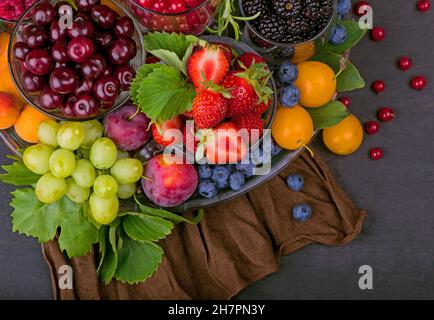 Verschiedene Sommerbeeren rote Johannisbeere, Stachelbeere, Himbeere in Glasschalen. Sortiert nach Art. Stockfoto