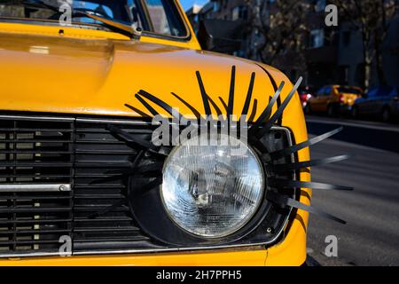 Details einer Lampe aus einem alten gelben Auto, das auf der Straße in Bukarest, Rumänien, dekoriert ist Stockfoto