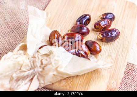 Süße getrocknete Datteln auf hellem Holzhintergrund in der Küche. Stockfoto