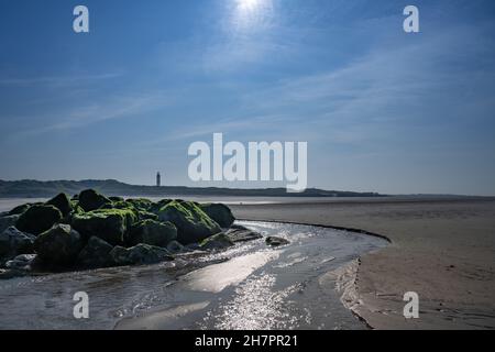 Panoramablick auf den Strand von Berck mit Felsformationen, die sich im Wasser spiegeln. Stockfoto