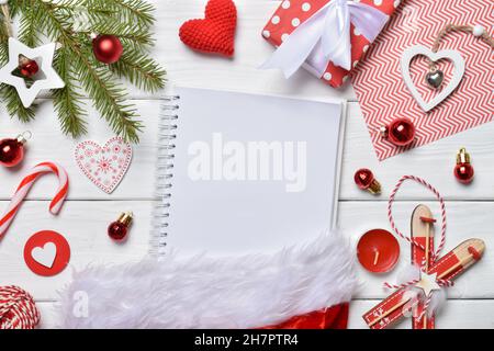 Draufsicht Schreiben der Neujahrsziele oder einer Einkaufsliste auf ein leeres Blatt Papier. Weihnachtliches Layout. Design für das neue Jahr. Stockfoto