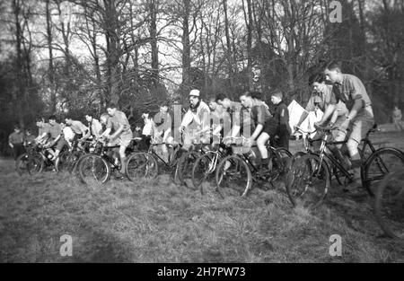 1939, historisch. pfadfinderlager, draußen auf einem Feld in langem, schwerem Gras, Beginn eines Gruppenzyklus, England. VEREINIGTES KÖNIGREICH. Stockfoto