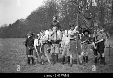 1939, historisches Pfadfinderlager, weibliche Pfadfindermeisterin mit einer Gruppe von jungen Pfadfindern auf dem Feld, al in Uniform, aber einige verkleidet, die einen kommunistischen Umzug abgewiesen haben, England, Großbritannien. Stockfoto