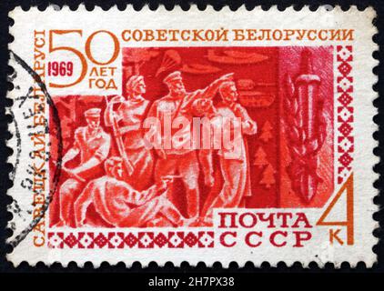 RUSSLAND - UM 1969: Eine in Russland gedruckte Marke zeigt Partisanen und Schwert, 50th. Jahrestag der weißrussischen Sowjetrepublik, um 1969 Stockfoto