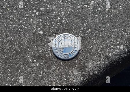 Ein Medaillon im Boden verbietet das Dumping im Sturmwasserkanal. Stockfoto