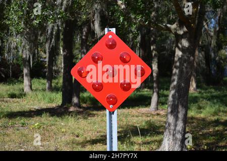 Ein leuchtendes rotes Schild mit roten reflektierenden Linsen. Stockfoto