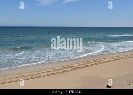 Die Traktoren hinterließen entlang der Küste tiefe Spuren im Sand. Stockfoto