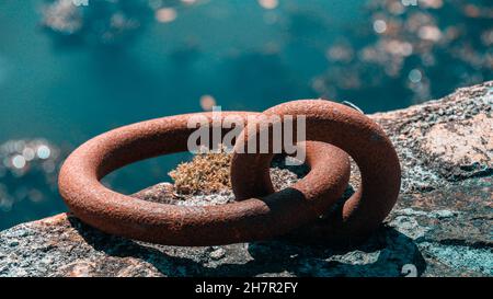 Nahaufnahme eines rot verwitterten alten rostigen Festmacherrings unter dem Sonnenlicht Stockfoto