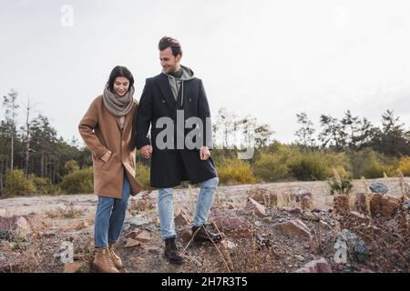 Junges Paar im Herbst-Outfit, das beim Spaziergang im Freien die Hände hält Stockfoto