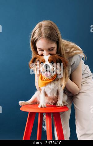 Nahaufnahme eines Porträts einer jungen Frau und ihres kleinen Hundes im Studio Stockfoto