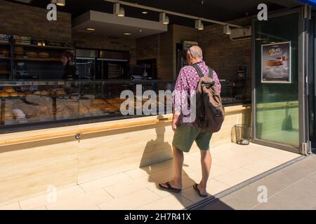Baska, Kroatien - 4th. September 2021. Ein Tourist versucht, sich aus einer großen Auswahl an süßen und herzhaften Backwaren in einer Bäckerei in Baska, Insel Krk, zu entscheiden. Stockfoto