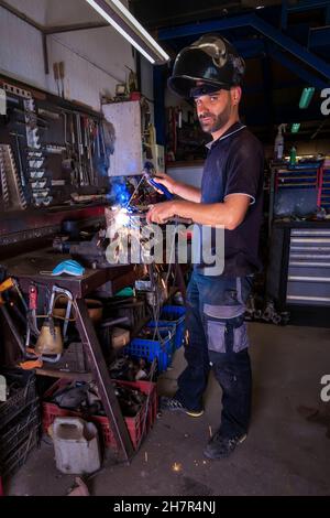 Schweißer, der in der Werkstatt mit elektrischer Lanze arbeitet. Stockfoto