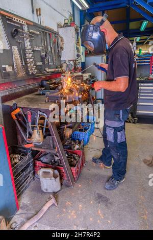 Schweißer, der in der Werkstatt mit elektrischer Lanze arbeitet. Stockfoto