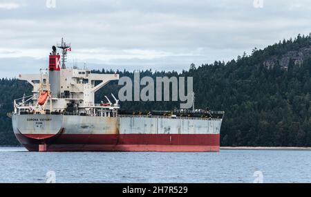 Meereshöhe, Dreiviertelansicht eines der vielen riesigen Frachter, die in den Gulf Islands von British Columbia verankert sind und darauf warten, den Hafen von Vancouver zu erreichen. Stockfoto