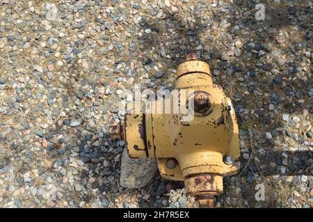 Draufsicht auf den alten verrosteten gelben Hydranten. Stockfoto