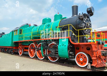 Alte Dampflokomotive 1935-1957 Grün mit roten Rädern. Renoviert, steht es als Museumsstück an der Eisenbahn. Stockfoto