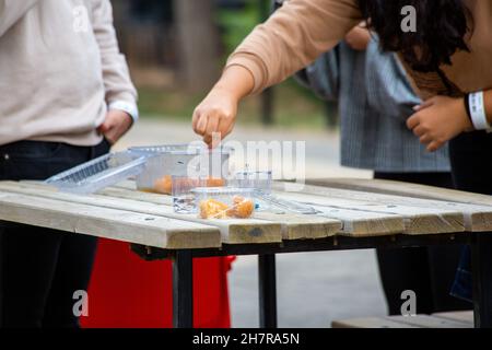 Übergewichtige Frau, die Knödel isst. Person, die Süßigkeiten in der Hand hält Stockfoto