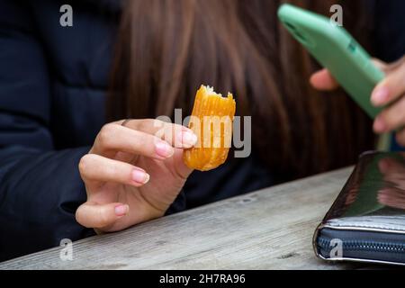 Übergewichtige Frau, die Knödel isst. Person, die Süßigkeiten in der Hand hält Stockfoto