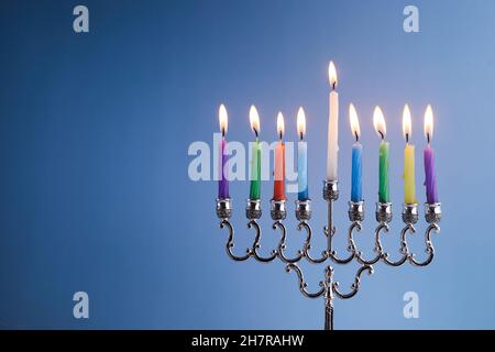 Jüdischer Feiertag Chanukka Hintergrund mit Menorah traditionellen Kerzenleuchtern und Kerzen auf blauem Hintergrund Stockfoto