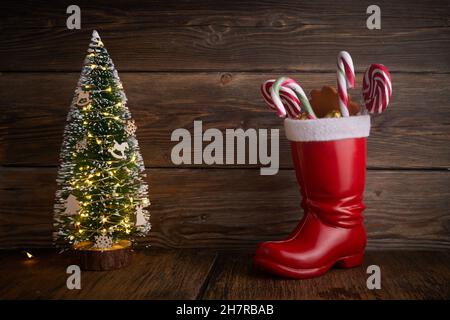 Weihnachtsstiefel mit Süßigkeiten und Geschenken zum Nikolastag am 6th. Dezember. Stockfoto