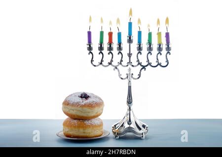 Jüdischer Feiertag Chanukka Hintergrund mit Menorah- traditionelle Kerzenleuchter, Kreisel Dreidel und Donut auf weißem Hintergrund Stockfoto