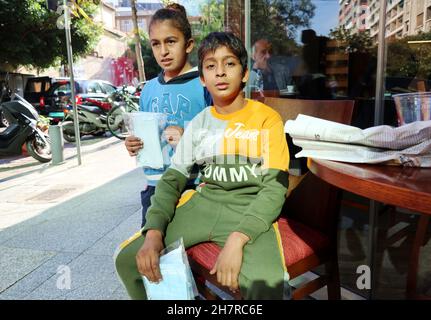 Zwei Kinder verkaufen am 24. November 2021 in einer Straße in Beirut, Libanon, Gesichtsmasken. Am 23. November stellte UNICEF den Bericht „ohne die Grundlagen überleben; die sich immer weiter verschärfenden Auswirkungen der Libanonkrise auf Kinder“ vor. Der Bericht basiert auf zwei Erhebungen, die von UNICEF im April 2021 und erneut im Oktober 2021 unter denselben Familien durchgeführt wurden.der Bericht vom November 22 zeigt einen Anstieg der Zahl der hungernden Kinder, die arbeiten müssen, um ihre Familie zu unterstützen, Nicht zur Schule gehen und nicht die Gesundheitsversorgung bekommen, die sie brauchen. Die Zahlen zeigen eine dramatische Verschlechterung der Lebensbedingungen über einen Zeitraum von sechs Monaten Stockfoto