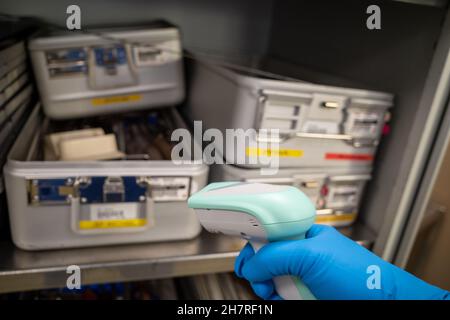 Einige Instrumentenbehälter werden in einem Operationssaal mit einem Handscanner erkannt Stockfoto