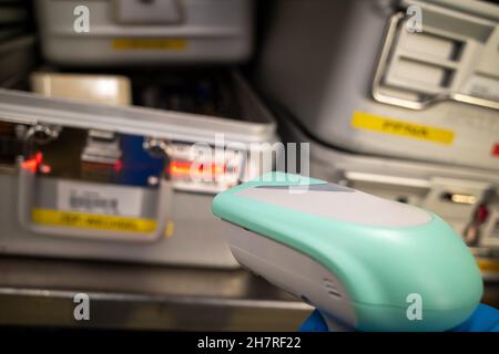 Einige Instrumentenbehälter werden in einem Operationssaal mit einem Handscanner erkannt Stockfoto