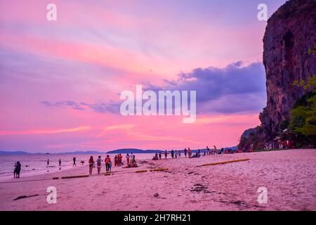 Die Massen von Touristen am Railay Beach am Abend genießen großen Sonnenuntergang und spektakulären bunten Himmel, Krabi Region, Thailand Stockfoto