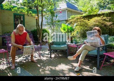 MEMPHIS, TN, USA - 29. AUGUST 2021: Mann und Frau lesen die Zeitung auf der Terrasse Stockfoto