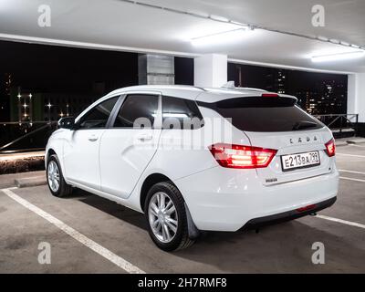 Moskau. Russland. 15. September 2021. Rückansicht eines weißen Autos Lada Vesta SW auf einem mehrstöckigen Parkplatz vor dem Hintergrund der Nachtstadt. Der Lada Vesta SW Kombi ist ein modernes russisches Auto. Stockfoto