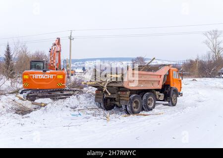 23. januar 2021, Kemerowo, Russland. Reinigung von Büschen und Unterholz der Baustelle mit einem orangefarbenen Hitachi Bagger Stockfoto