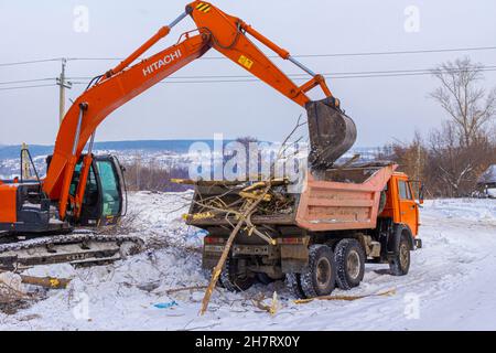 23. januar 2021, Kemerowo, Russland. Vorbereitung der Baustelle für den Baubeginn und Verladung von Baumfragmenten in den Körper eines Muldenkipper U Stockfoto