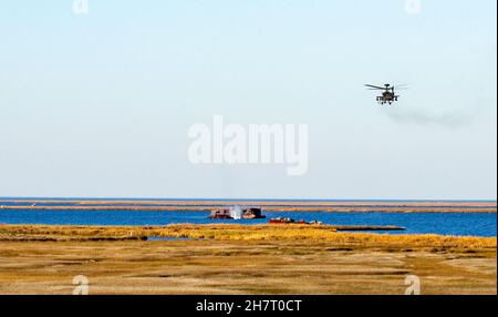 Eine Rakete aus dem Jahr 70mm, die von einem Hubschrauber der US-Armee AH-64E Apache abgeschossen wurde, trifft auf ein stationäres Wasserziel vor dem Ufer des Bombenziels Target 11 (BT-11) auf Piney Island, North Carolina, während der Operation Razor Talon, 17. November 2021. Die BT-11 Range, eine Satellitenanlage der Marine Corps Air Station Cherry Point, wurde von Soldaten der US-Armee verwendet, die der Charlie Company, dem 1st Bataillon, dem 101st Aviation Regiment und der 101st Airborne Division aus Fort Campbell, Kentucky, zugewiesen wurden. (USA Marine Corps Foto von Lance CPL. Lauralle Walker) Stockfoto