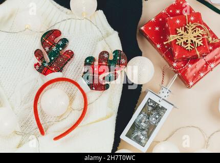 Brauner Strickpullover und Girlanden, LED-Leuchten. Frauen Mode Winterkleidung und Accessoires. Neues Jahr und Weihnachtsfeier Mockup. Weihnachten Stockfoto